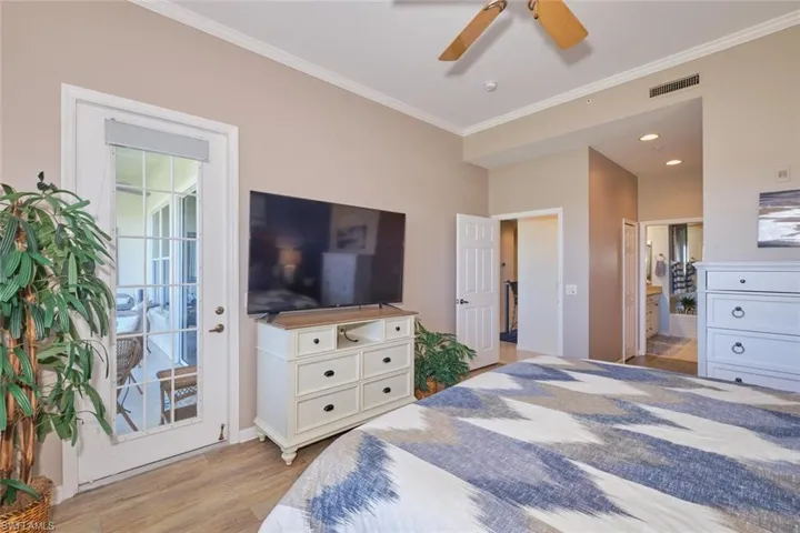 Bedroom with light wood-type flooring, ornamental molding, access to outside, ceiling fan, and multiple windows