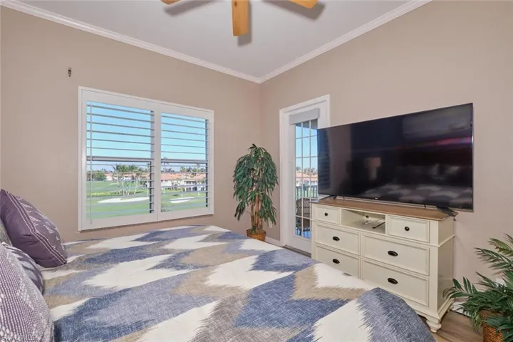 Bedroom with multiple windows, ceiling fan, crown molding, and wood-type flooring