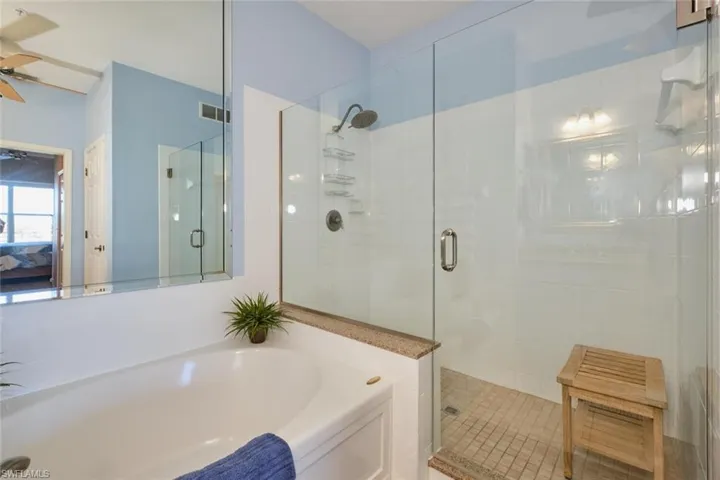 Bathroom featuring ceiling fan and plus walk in shower