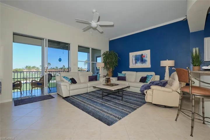 Tiled living room with crown molding and ceiling fan
