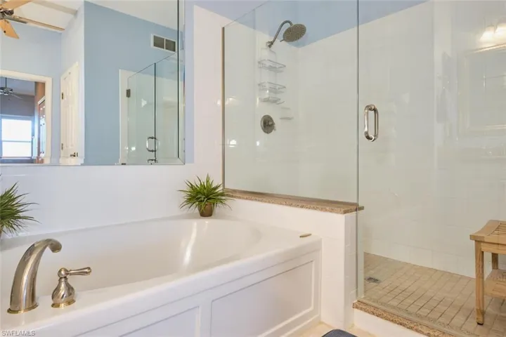 Bathroom with ceiling fan and plus walk in shower