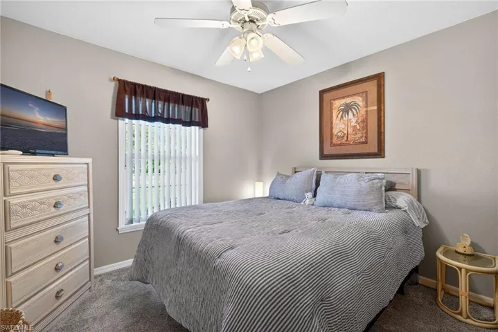 Carpeted bedroom with baseboards and a ceiling fan
