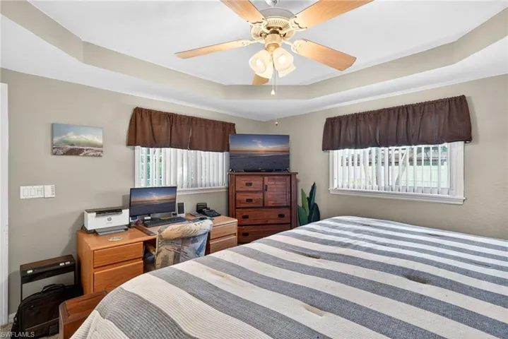 Bedroom featuring a raised ceiling and ceiling fan