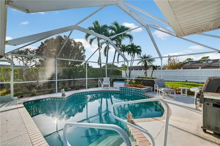 View of swimming pool featuring a sunroom, patio surround, and glass enclosure