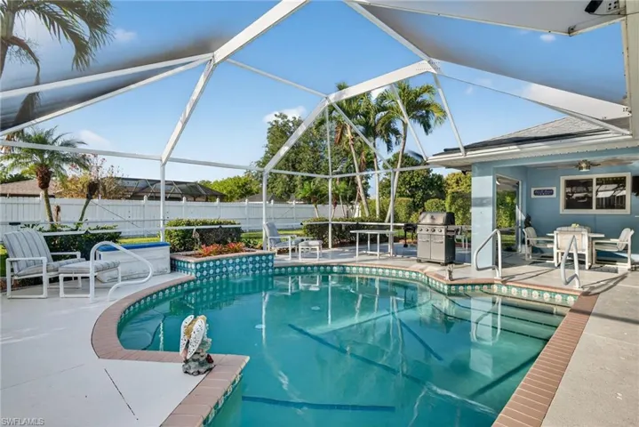 View of pool with patio surround, a lanai, a sunroom, and outdoor dining area
