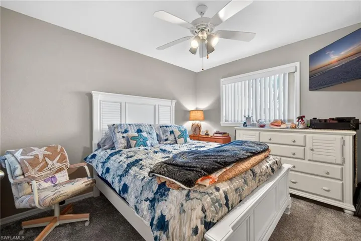 Bedroom featuring dark colored carpet and a ceiling fan