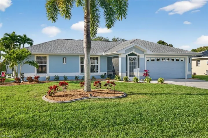 Single story home featuring stucco siding, an attached garage, a front yard, and driveway