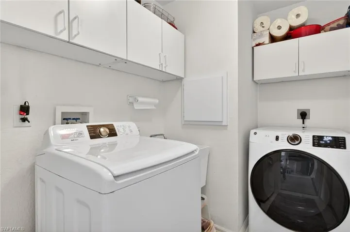 Laundry room featuring cabinet space and washer and clothes dryer