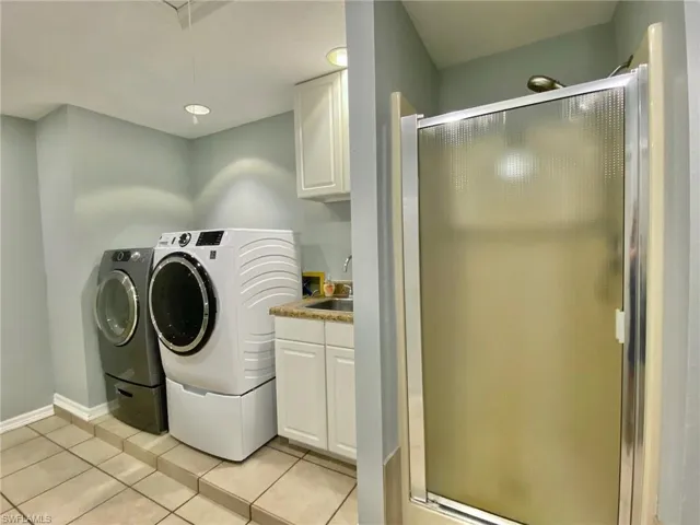 Laundry/mud room with a 3rd shower, washer, dryer and utility sink.