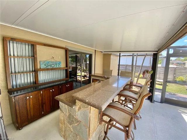Custom built matching quartz stone wet bar with a mini fridge, stereo and Bose speakers in the two corner planters.  Custom built wall unit holds your favorite liquor bottles and is wired for a TV.