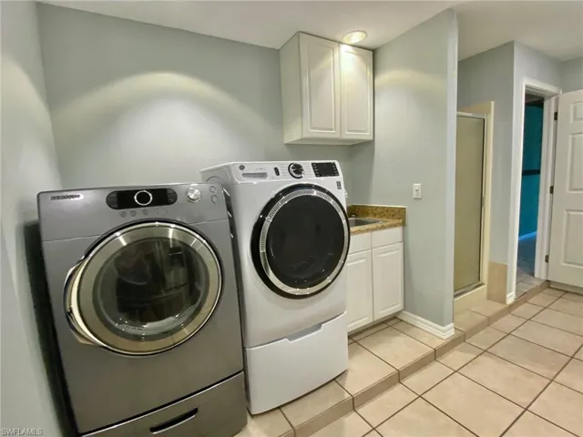 Laundry/mud room with a 3rd shower, washer, dryer and utility sink.
