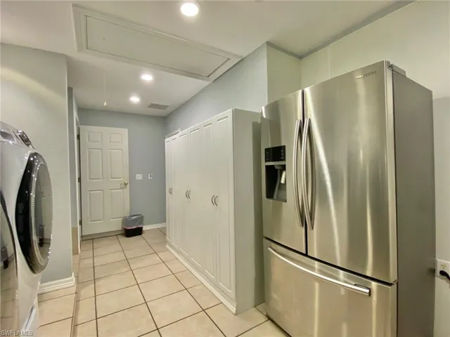Laundry/mud room with pull down attic stairs, additional pantry storage and a 2nd refrigerator.