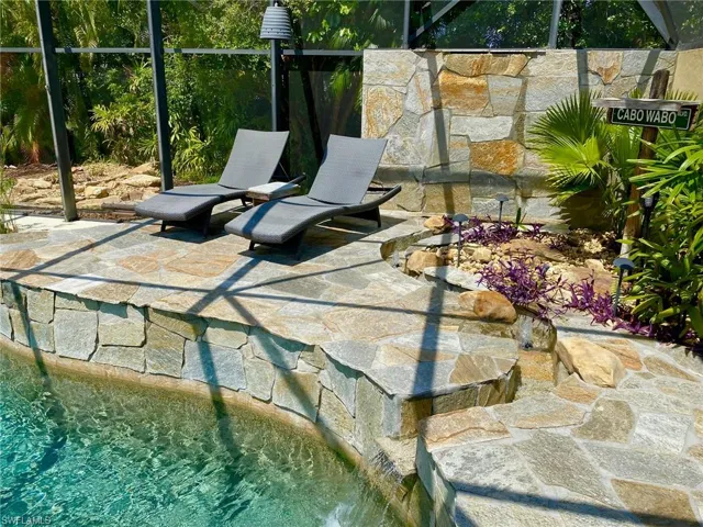 Elevated tanning deck by the wall waterfall and curvy channel with 3 bubblers inside!