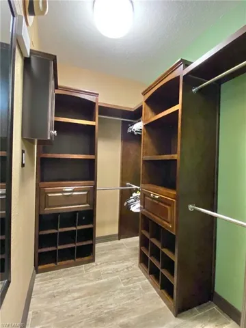 Master bathroom walk in closet with a convenient pocket door, hands free motion light sensor, and a custom closet organizer.