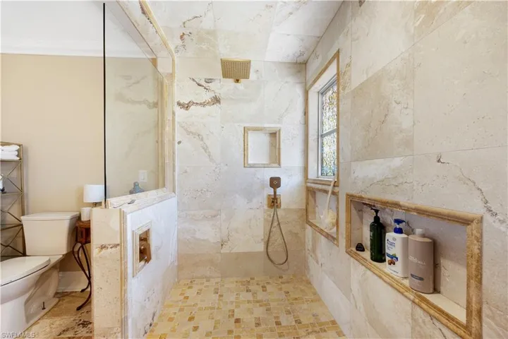 Bathroom featuring a walk in shower and toilet
