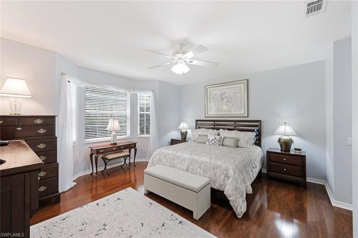 Large primary bedroom with wood flooring and the incredible lake view.