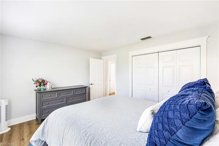Interior room featuring light-toned wall paint and wood-finish flooring