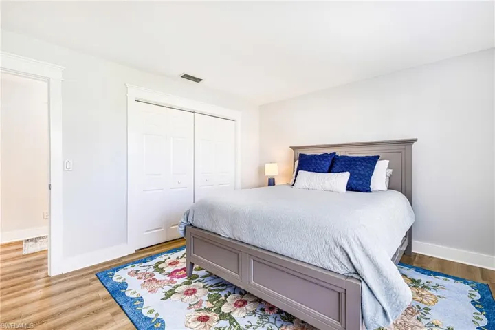 Interior room with light gray walls, wood-finish flooring, and white trim molding