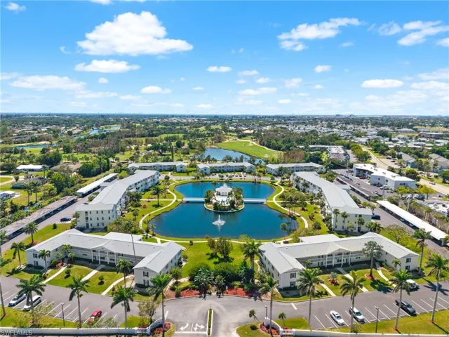 Expansive community featuring multiple residential buildings surrounding a central lake with a decorative fountain