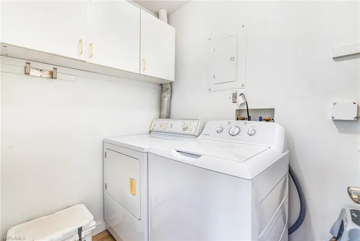 Dedicated laundry area featuring upper white cabinetry, a built-in dryer vent, and plumbing hookups