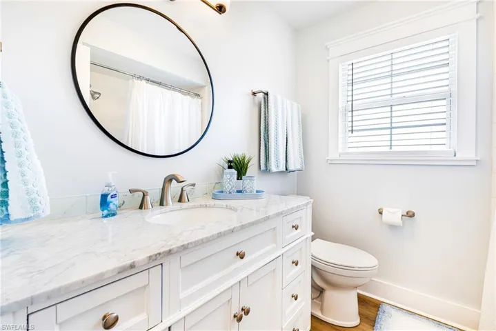Vanity featuring a stone countertop, an undermount sink, and brushed nickel fixtures