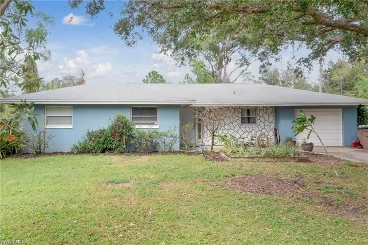 Ranch-style house with a garage and a front lawn