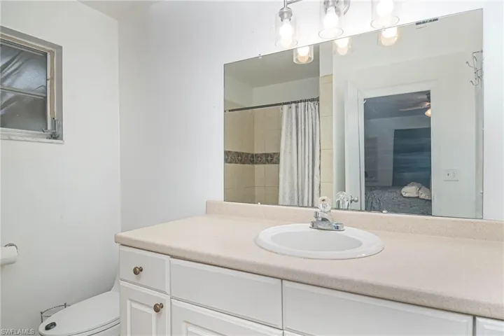 Bathroom with vanity, a shower with curtain, and toilet
