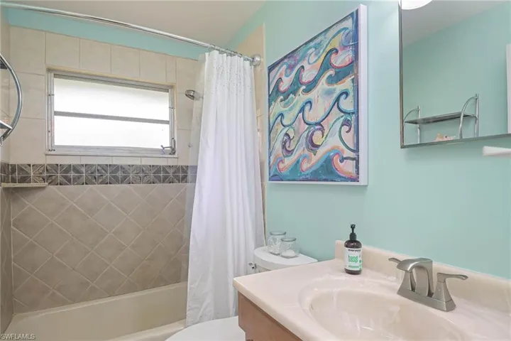 Full bathroom with vanity, toilet, and shower / bath combo with shower curtain