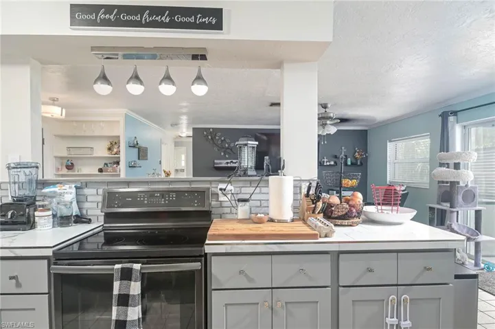 Kitchen featuring decorative backsplash, gray cabinetry, electric stove, a textured ceiling, and ceiling fan