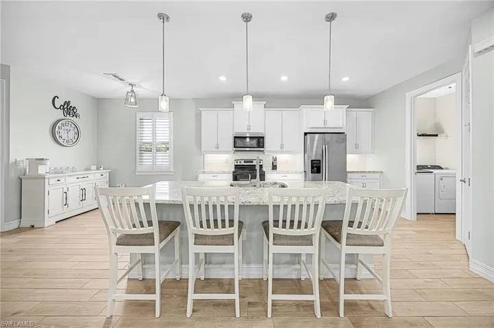 Oversized kitchen island with abundant seating and prep space, ideal for hosting gatherings, casual dining, or meal preparation in this chef-inspired kitchen.