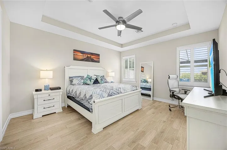 Spacious primary suite with tray ceiling, abundant natural light —offering a true retreat within this Cape Coral pool home.