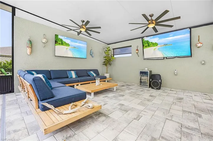 Outdoor living room complete with multiple TVs—perfect for game day, movie nights, or relaxing poolside in your private backyard oasis.  The perfect space to watch both games at once on Sunday!