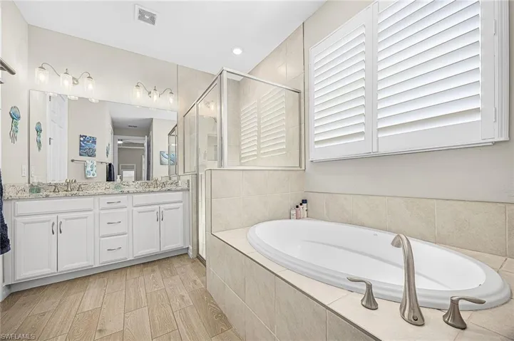 Luxurious primary bathroom featuring dual vanities, soaking tub, and a walk-through shower—designed for comfort, relaxation, and spa-like living.