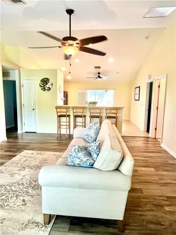 Living room featuring ceiling fan, vaulted ceiling, and hardwood / wood-style floors