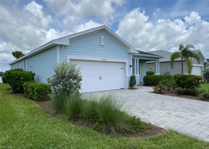 View of front facade with stucco siding, an attached garage, and decorative driveway