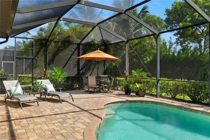 View of pool featuring a patio and glass enclosure