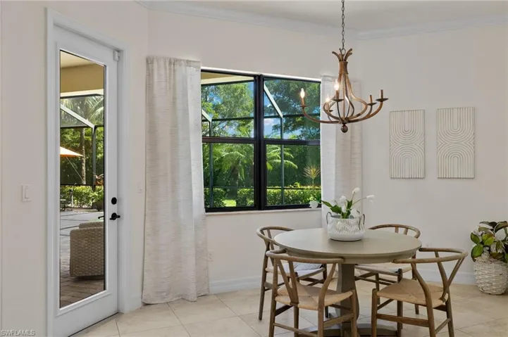 Dining area featuring a notable chandelier, light tile patterned floors, and crown molding