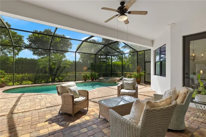 View of pool with an in ground hot tub, a lanai, ceiling fan, and a patio area