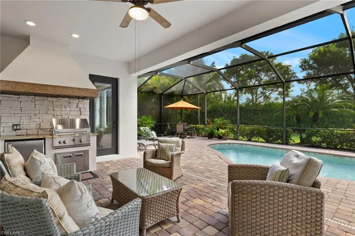 View of patio / terrace with ceiling fan, grilling area, an outdoor kitchen, and a lanai