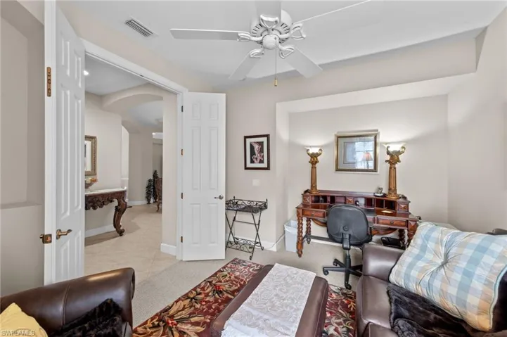 Office with arched walkways, ceiling fan, and light tile patterned floors