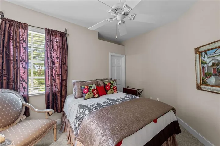 Carpeted bedroom featuring a ceiling fan and baseboards