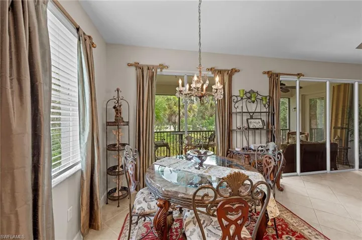 Dining space featuring light tile patterned flooring, a chandelier, and plenty of natural light