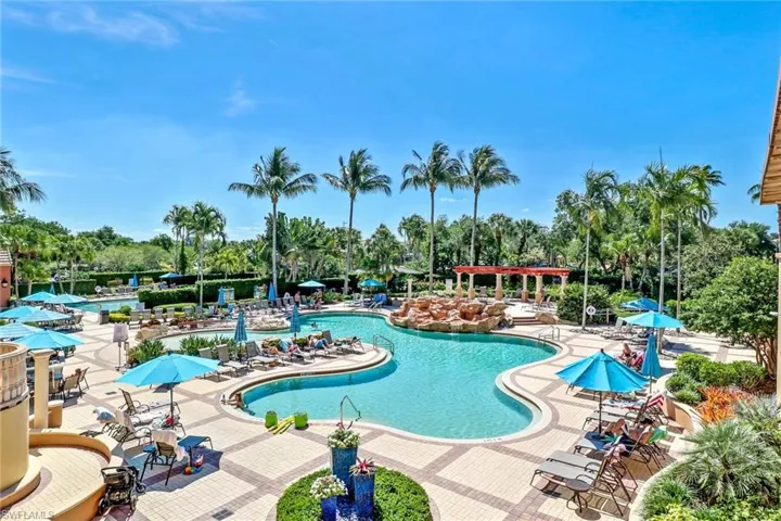 Community pool featuring a patio and view of wooded area