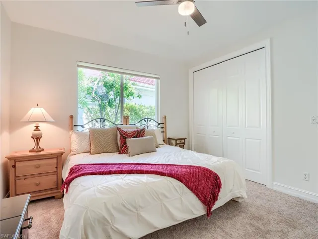 Bedroom with ceiling fan, a closet, and carpet