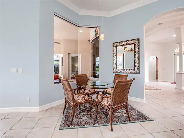 Tiled dining area featuring crown molding and a wealth of natural light