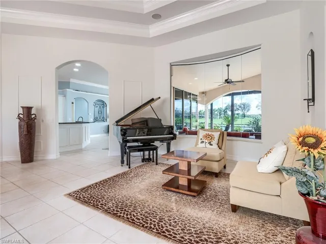 Sitting room with ceiling fan, crown molding, and tile patterned flooring