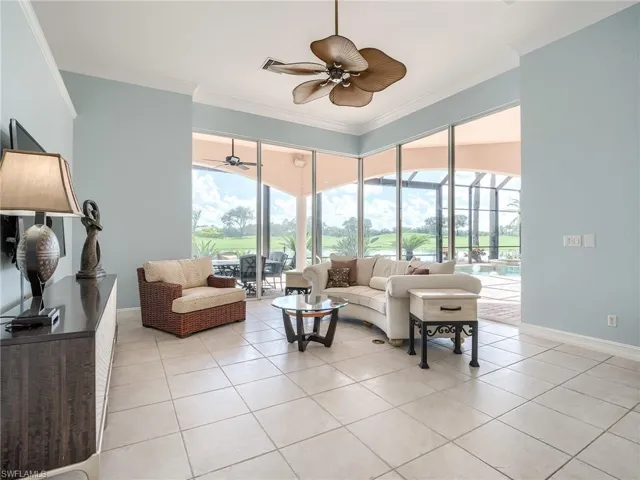 Tiled living room featuring ornamental molding, a wealth of natural light, and ceiling fan