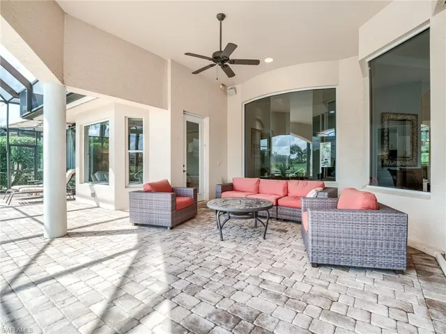 View of patio featuring an outdoor hangout area, screened enclosure, and ceiling fan