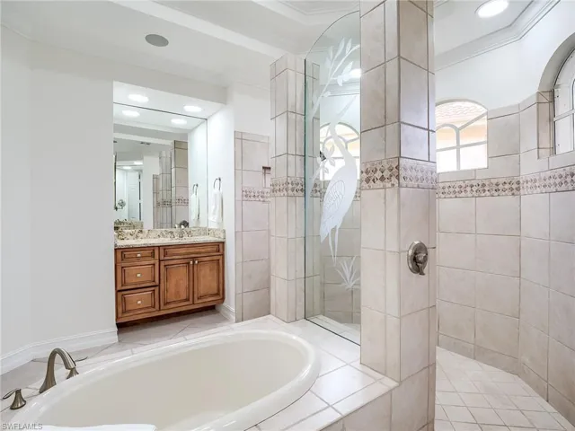 Bathroom with independent shower and bath, vanity, and crown molding