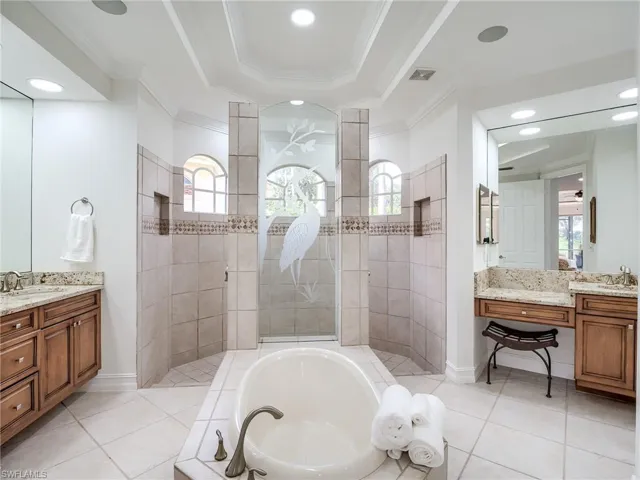 Bathroom with ornamental molding, shower with separate bathtub, plenty of natural light, and vanity